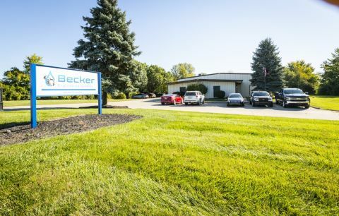 Becker employees standing next to Becker sign